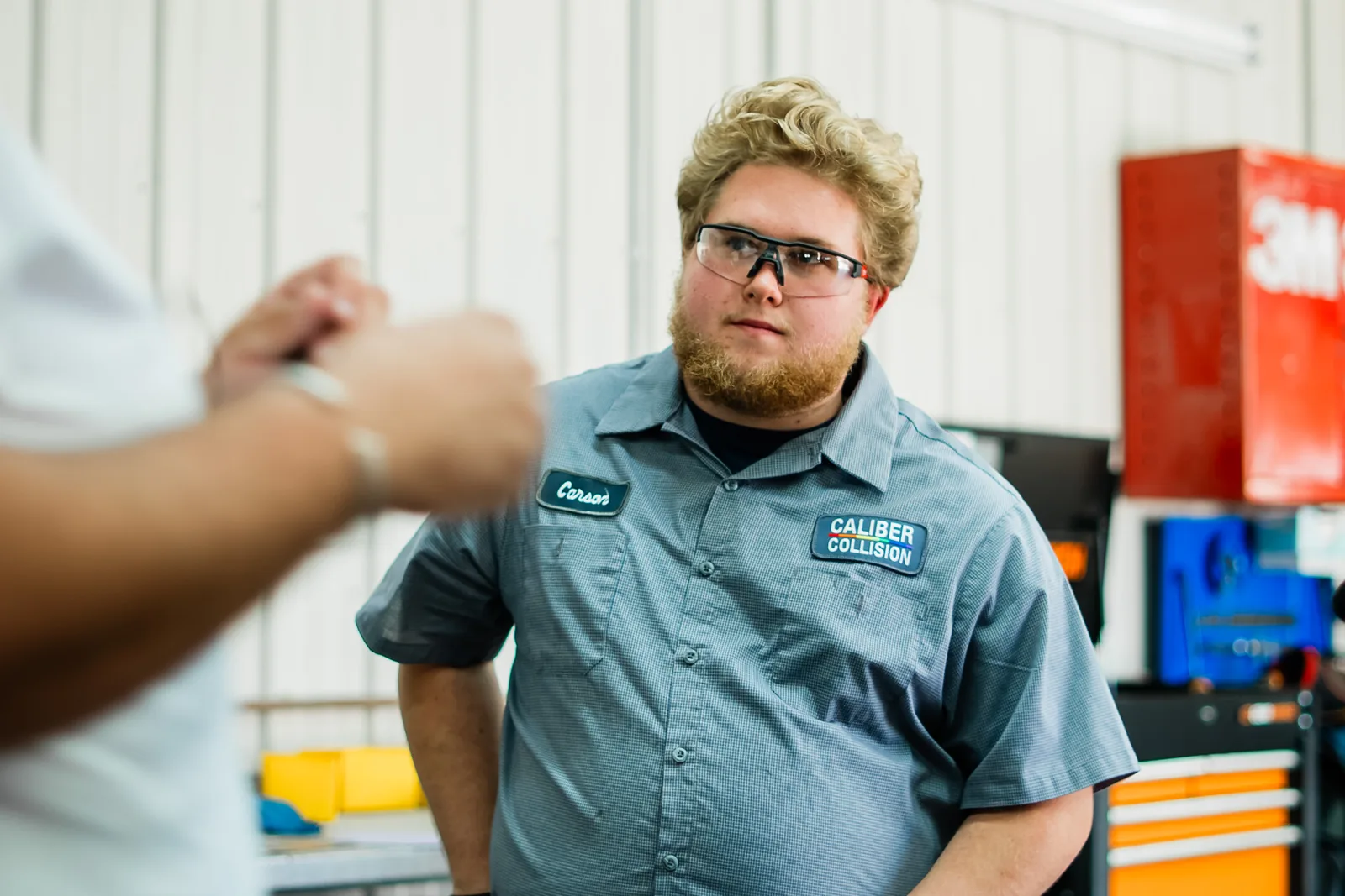 A student in a Caliber Collision shirt talks with an interviewer at a Jumpstart Draft Day.