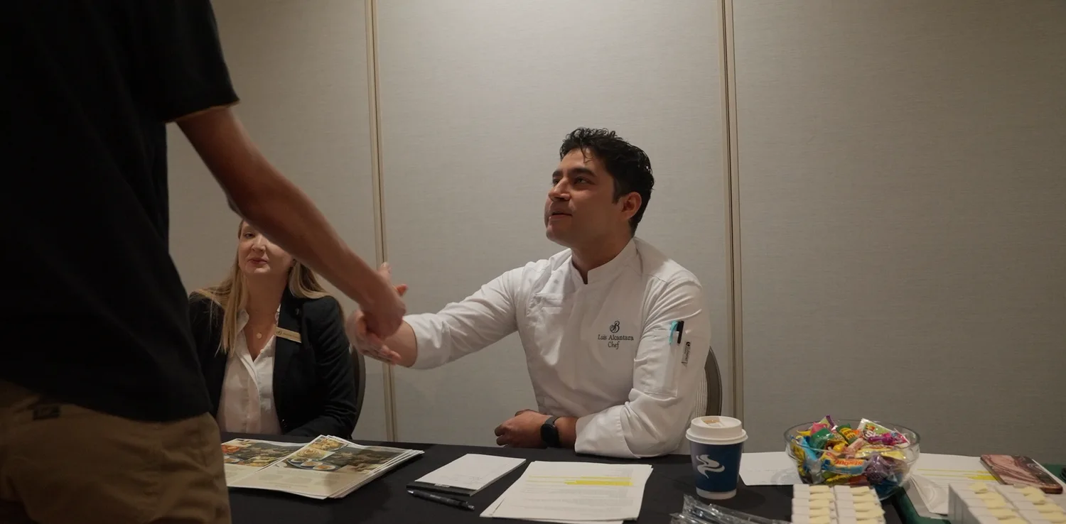 A student shakes hands with a local employer at a Jumpstart Draft Day.